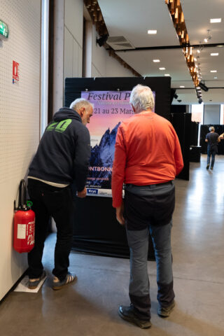 Patrick et Régis installent l'affiche du festival à l'entrée